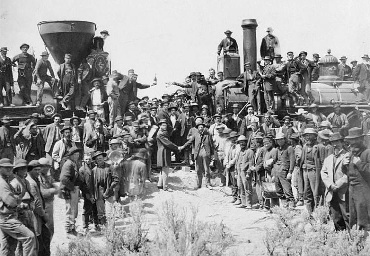 The ceremony for the driving of the golden spike at Promontory Summit, Utah on May 10, 1869; completion of the First Transcontinental Railroad. At center left, Samuel S. Montague, Central Pacific Railroad, shakes hands with Grenville M. Dodge, Union Pacific Railroad (center right).